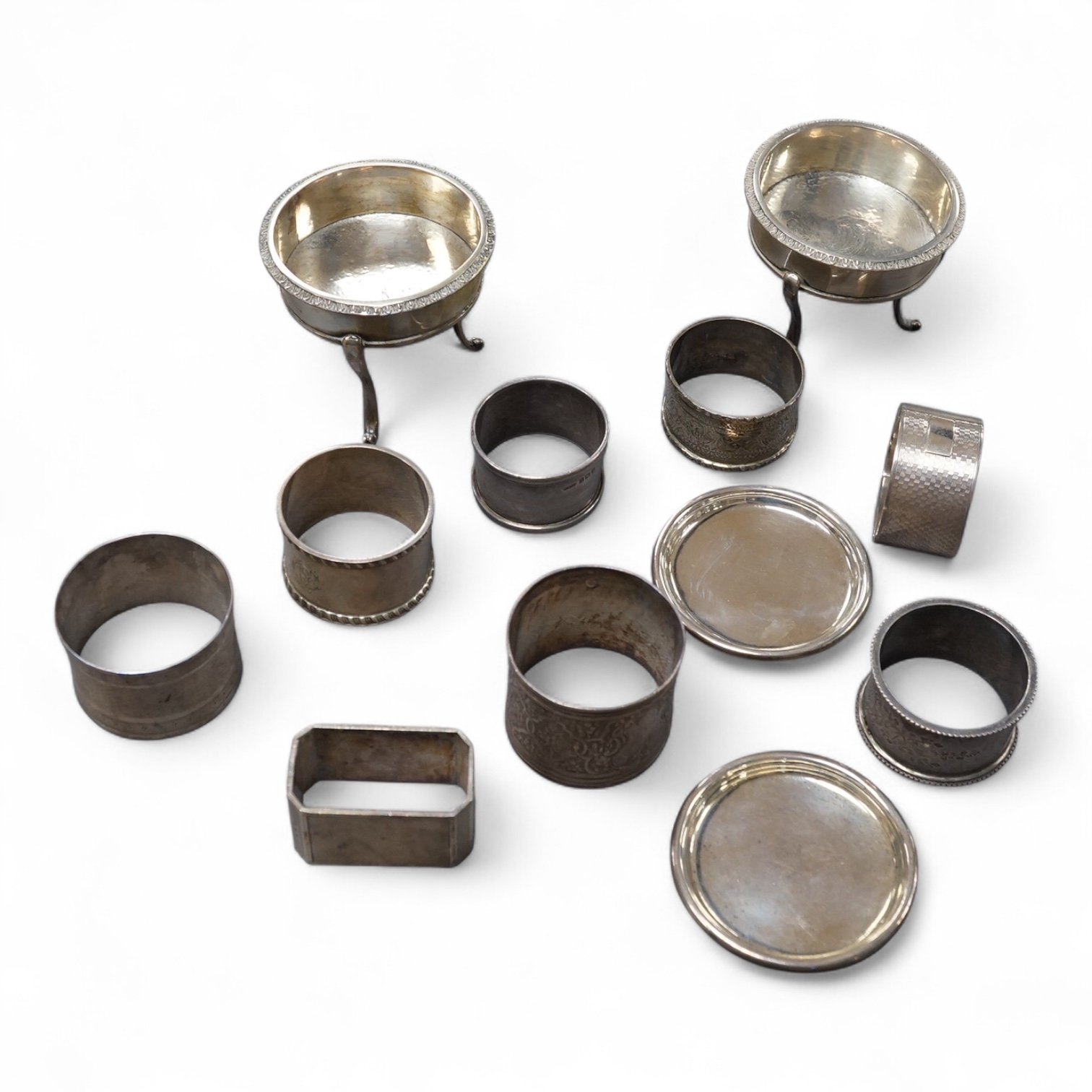 A pair of 19th century tripod salts, height 60mm, together with eight assorted silver napkin rings and a pair of small Victorian silver coasters?, 16.5oz.